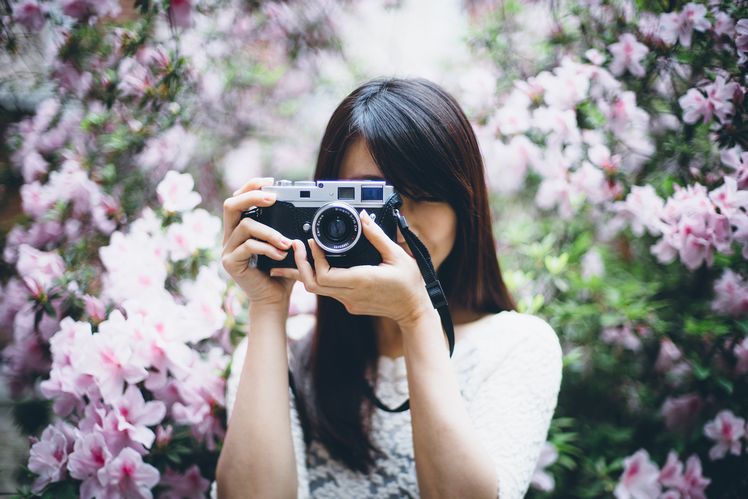 Use a large aperture lens to make the background rhododendron into a dreamy and interesting background